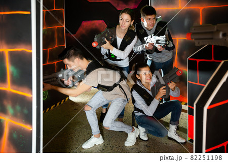 Positive young people posing with laser guns Positive young people posing with laser guns 82251198