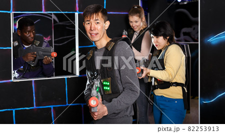 Chinese man during lasertag game in dark room Chinese man during lasertag game in dark room 82253913