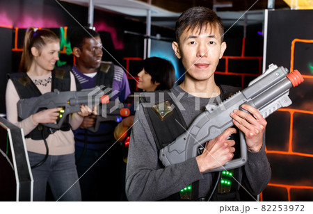 Asian man with laser gun ready for lasertag game 82253972
