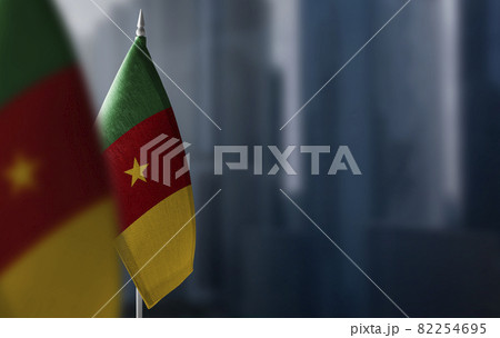 Small flags of Cameroon on a blurry background of the city 82254695