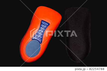 The orthopedic insole on a black background. 82254788