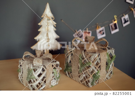 Christmas gift boxes on the table surface with white decorative xmas tree and garland Christmas gift boxes on the table surface with white decorative xmas tree and garland 82255001