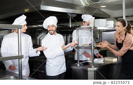 Chef of restaurant with team of cooks preparing food Chef of restaurant with team of cooks preparing food 82255073