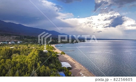 Idyllic summer landscape with lake near mountain with reflection from clouds and forest. Issyk kul, Kyrgyzstan. 82256605