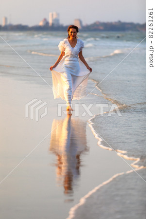 Woman in white dress on beach Woman in white dress on beach 82261261