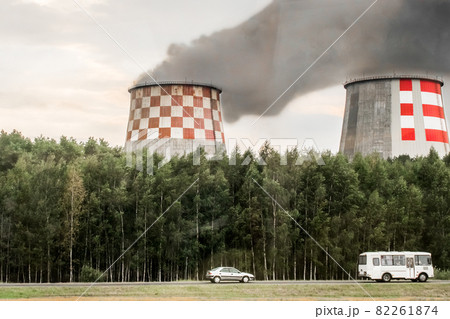 Dirty smoke is released from the cooling tower of the industrial plant and pollutes the environment, nature and atmosphere Dirty smoke is released from the cooling tower of the industrial plant and pollutes the environment, nature and atmosphere 82261874