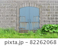 石積みの壁と錆びた青色の鉄扉 82262068