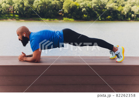 Young athlete running fast outdoors. Wearing sport cloth, doing wide step, demonstrating healthy way of life, wide shot. 82262358