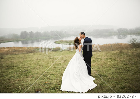 Gorgeous happy couple standing close to each other and looking in eyes Gorgeous happy couple standing close to each other and looking in eyes 82262737