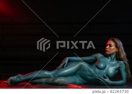 Gorgeous naked brunette posing painted in turquoise sequins. 82263730