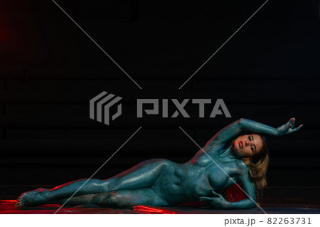 Gorgeous naked brunette posing painted in turquoise sequins. 82263731
