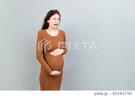 Sad and stressed pregnant woman isolated on colored background 82263749