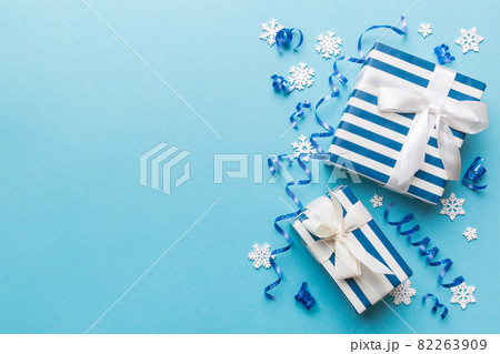 Holiday flat lay with gift boxes wrapped in colorful paper and tied decorated with confetti on colored background. Christmas, Birthday, Valentine and sale concept, top view Holiday flat lay with gift boxes wrapped in colorful paper and tied decorated with confetti on colored background. Christmas, Birthday, Valentine and sale concept, top view 82263909