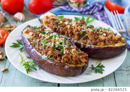 Healthy dinner. Snack. Stuffed with minced meat and vegetables eggplant on wooden table. Healthy dinner. Snack. Stuffed with minced meat and vegetables eggplant on wooden table. 82266525