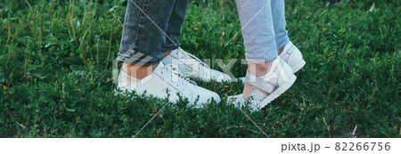 mother and daughter legs and shoes on the grass, only feet 82266756