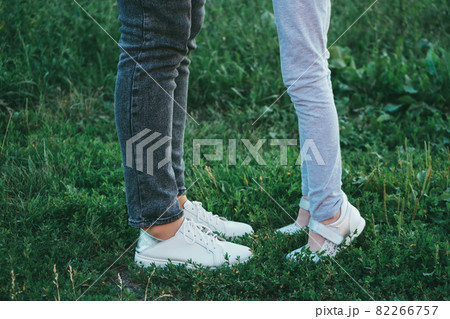 mother and daughter legs and shoes on the grass, only feet mother and daughter legs and shoes on the grass, only feet 82266757