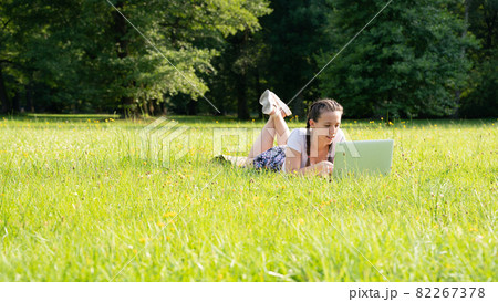 Computer outdoor. Student girl working on laptop, tablet in summer park. Woman person business nature outside with online technology. Electronic gadgets distance learning concept. 82267378