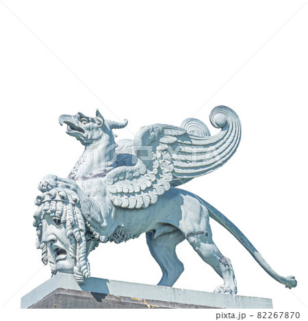 Old statue of medieval griffin, a hybrid of lion and bird, holding a theatre mask in historical and shopping downtown of Dresden, Germany, details, isolated at white background. Old statue of medieval griffin, a hybrid of lion and bird, holding a theatre mask in historical and shopping downtown of Dresden, Germany, details, isolated at white background. 82267870