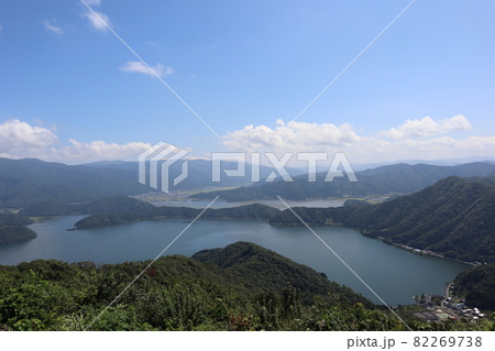 青空と白い雲と青い三方五湖の一部と色づく田んぼと町と連なる山々のある風景 青空と白い雲と青い三方五湖の一部と色づく田んぼと町と連なる山々のある風景 82269738