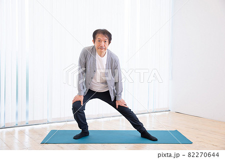 部屋でトレーニングをする中高年男性（屈伸・伸脚） 82270644