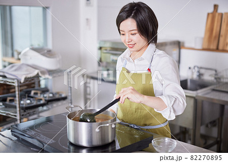 キッチンでカレーを作るエプロン姿の若い女性 キッチンでカレーを作るエプロン姿の若い女性 82270895
