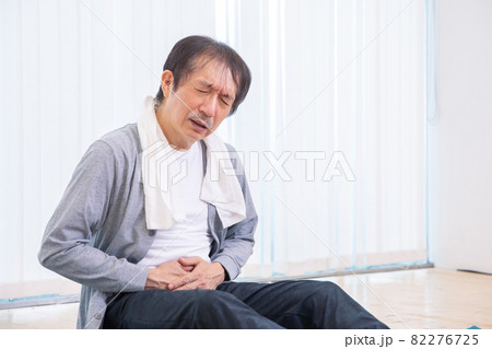 トレーニング中に痛がる中高年男性（腹痛） 82276725