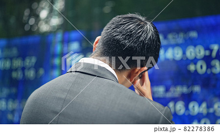 株価ボードの前で落ち込む男性 82278386