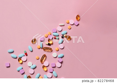 Pharmaceutical tablets and capsules on pink background. Medical health care concept. Pharmaceutical tablets and capsules on pink background. Medical health care concept. 82278468