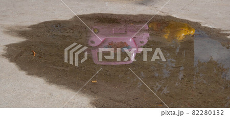 Pink children's car in the park , reflected in a puddle after the rain 82280132