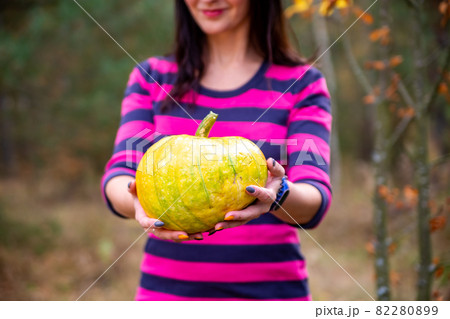 faceless woman holds with pumpkin in the autumn forest. halloween concept 82280899