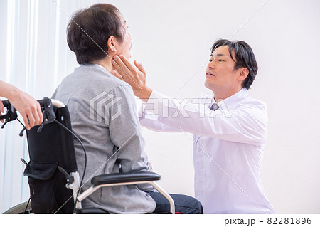 口を見る医師と車椅子に乗った患者（歯医者） 82281896