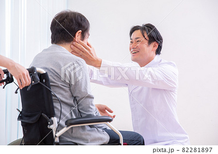 目を見る医師と車椅子に乗った患者（眼科） 82281897