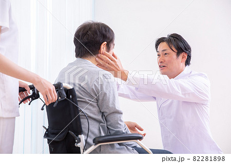 目を見る医師と車椅子に乗った患者（眼科） 82281898