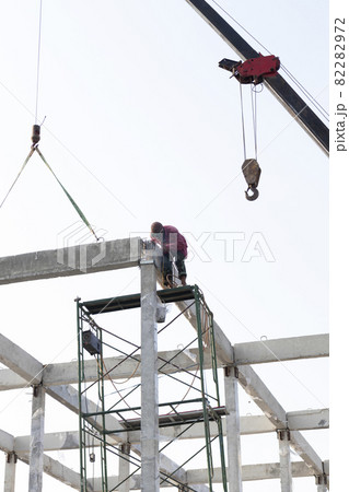 precast concrete beam intralled at construction site by mobile crane 82282972