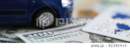 Closeup of plastic card, dollar bill and toy car lie on table at insurance company Closeup of plastic card, dollar bill and toy car lie on table at insurance company 82285414