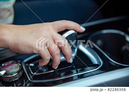 hand switches modes on the automatic transmission lever. close-up. no face hand switches modes on the automatic transmission lever. close-up. no face 82286308