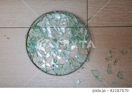 A close-up of a broken glass lid lies on a stake of tile. shards of glass shine. soft focus, top view 82287070