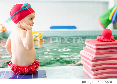 Child sitting at swimming pool Child sitting at swimming pool 82290701