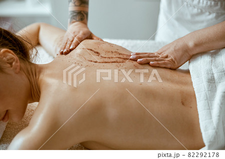 confident female specialist is doing relaxing body massage for beautyful slim caucasian lady at minimalistic spa salon 82292178