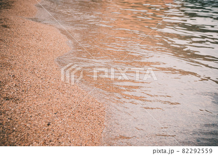 Sea beach in the tropics and the soft wave of the blue ocean. Summer gloomy day and sandy beach with stones background. The concept of summer vacation. 82292559