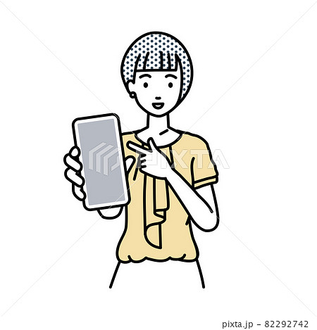 立ってスマートフォンを指差してこちらに向けて見せているオフィスカジュアルの女性 82292742