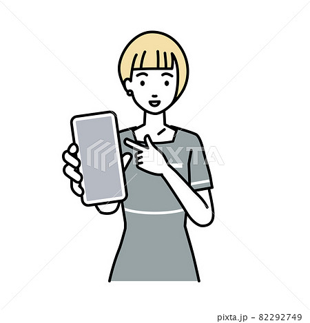 立ってスマートフォンを指差してこちらに向けて見せているエステ店員の女性 82292749