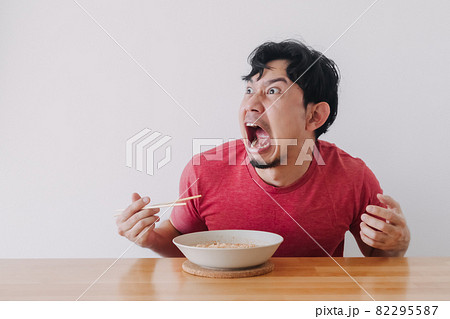 Funny face of man eat very hot and spicy instant noodle. 82295587