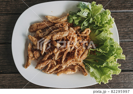 Thai crispy fish served in white dish decorated with vegetable. 82295997