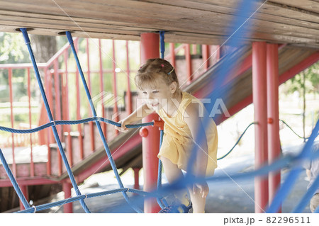 caucasian little girl playing on the playground on a summer day 82296511