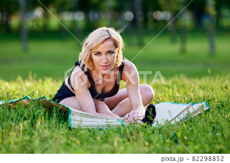 Elegant european woman trains yoga outdoors at summer day. 82298852
