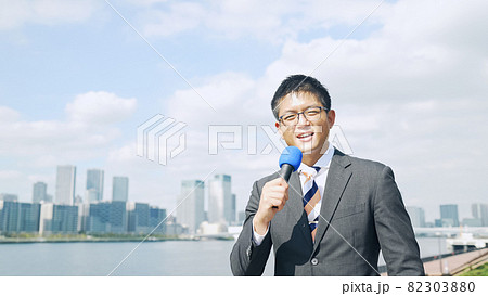 都市を背景に話す男性レポーター 82303880