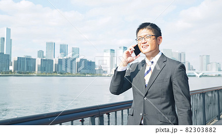 歩きながらスマホで通話する男性 歩きながらスマホで通話する男性 82303882