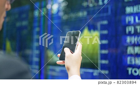 株価ボードの前でスマホを操作する男性 株価ボードの前でスマホを操作する男性 82303894