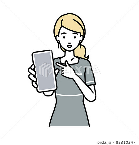 立ってスマートフォンを指差してこちらに向けて見せているエステ店員の女性 82310247